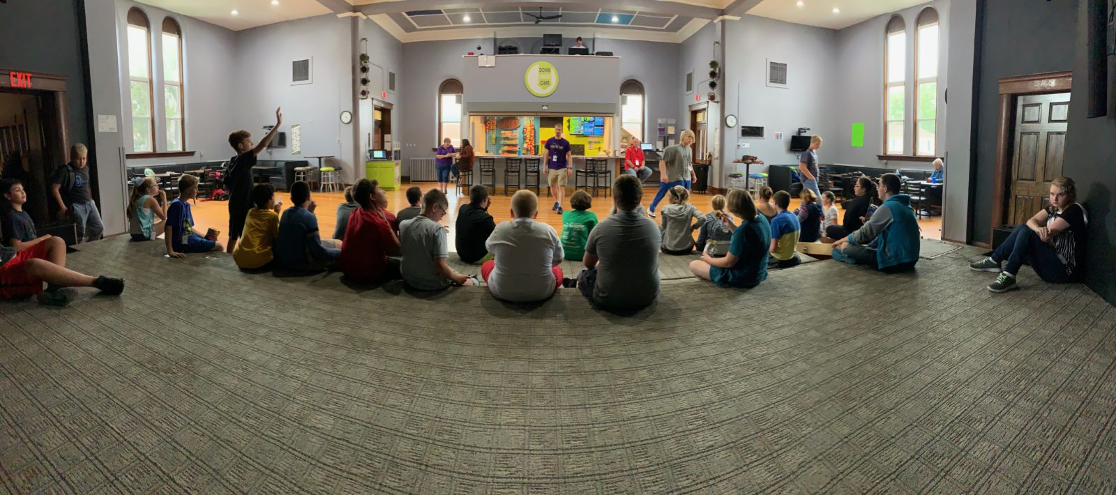 Students sitting in a circle on the floor during After-School Central