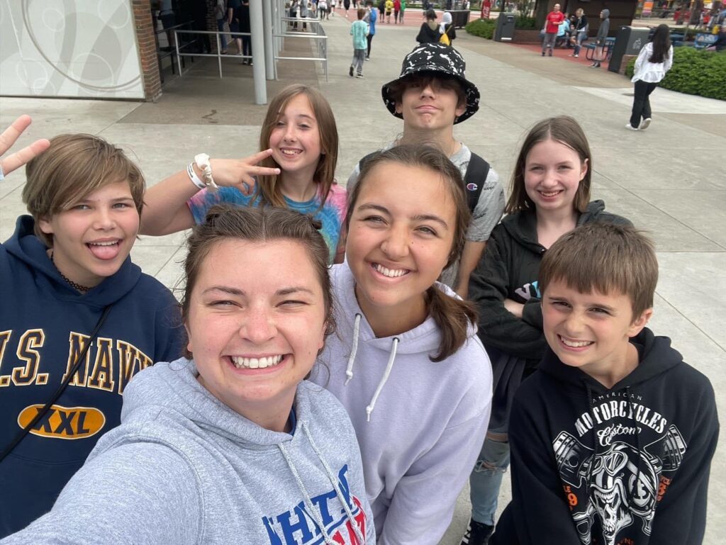 A group of smiling students taking a selfie at an event
