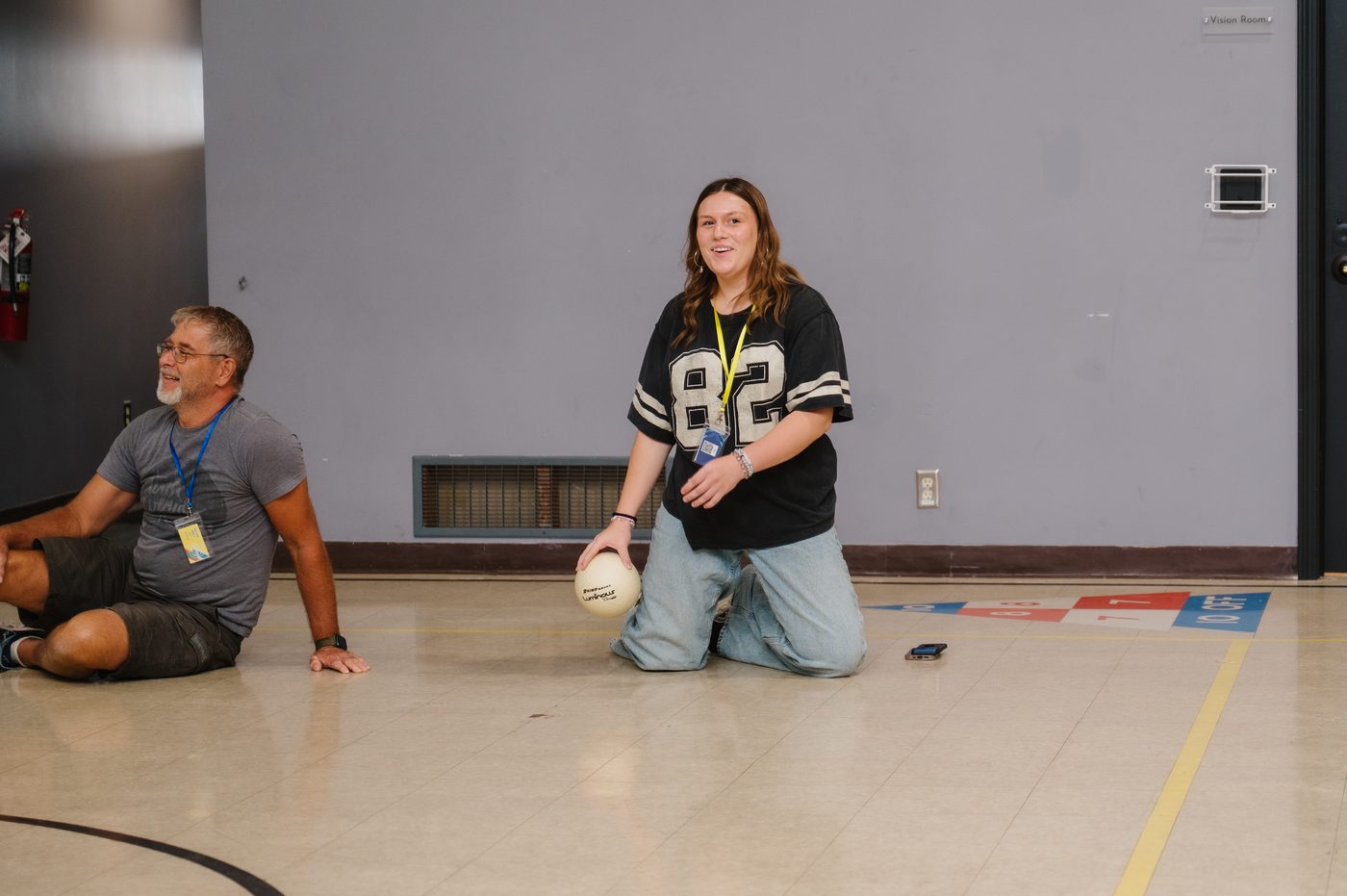 A high school volunteer leading a game in the gym