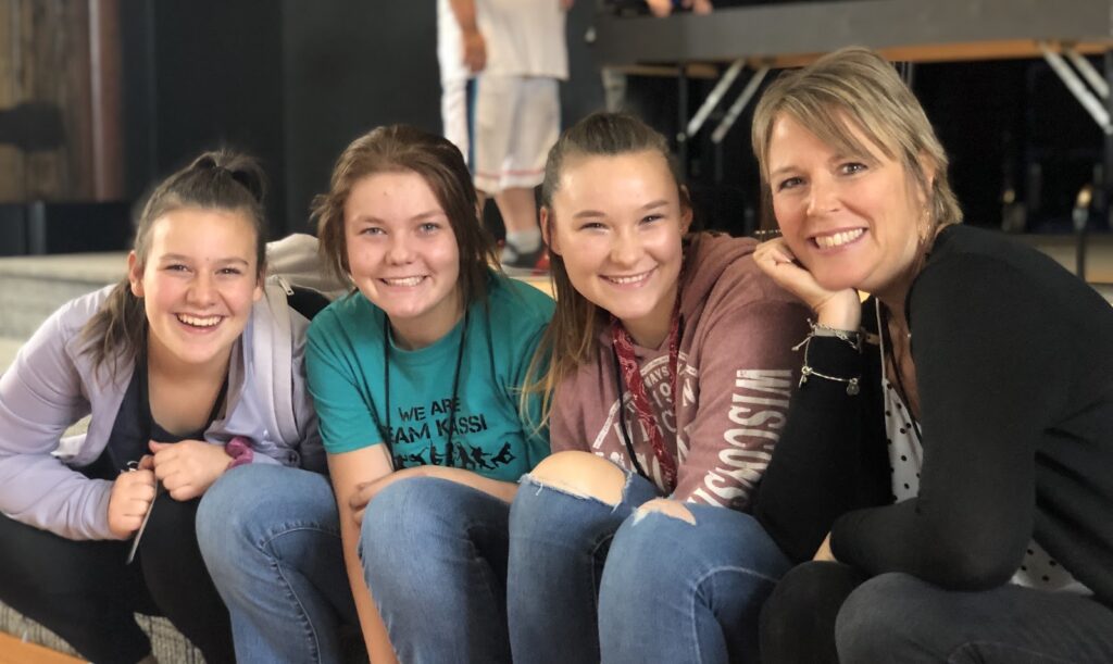Three students sitting with a staff member